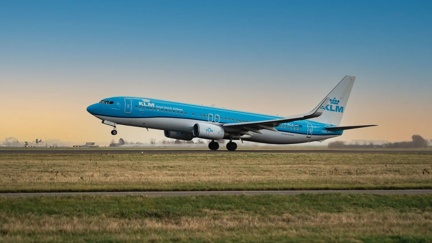 a blue and white airplane is on the runway